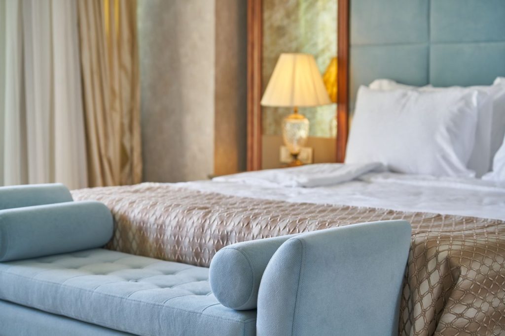 Crafting Captivating Headlines: Your awesome post title goes here Elegant bedroom interior featuring plush bed and seating with cozy ambiance lighting.