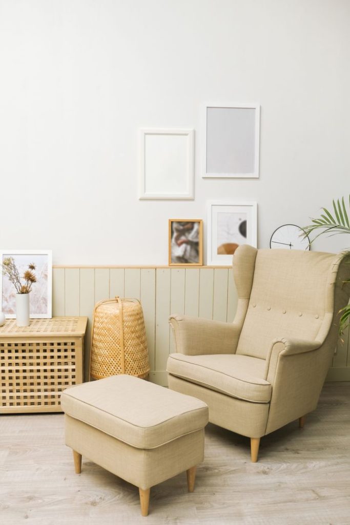 Cozy living room with beige armchair, pouf, and minimalist decor.